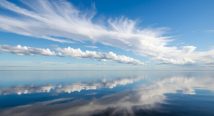 The contrast between the still water and the moving clouds.
