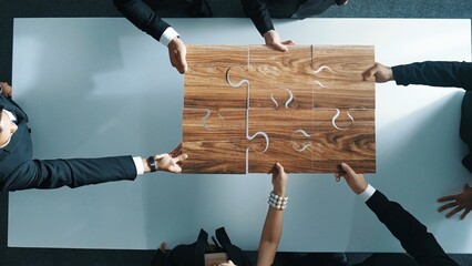 Top view of skilled businesspeople hand bring and fill the last jigsaw piece together. Group of...