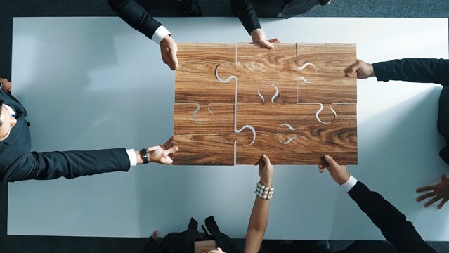 Top view of skilled businesspeople hand bring and fill the last jigsaw piece together. Group of project manager complete puzzle or solving problem. Unity, teamwork, successful project. Directorate.