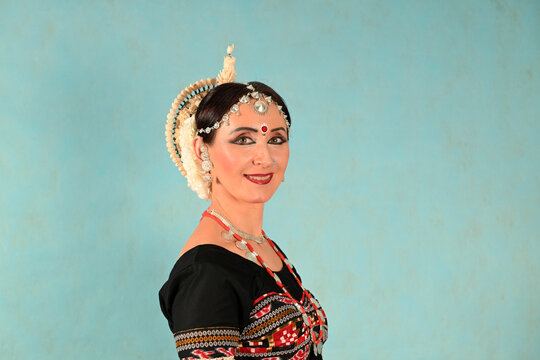 Indian dancer girl in studio on blue background in full-face close-up