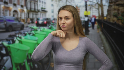 Young woman making a gesture on a busy city street with lime green bikes, conveying emotion in bustling urban environment.