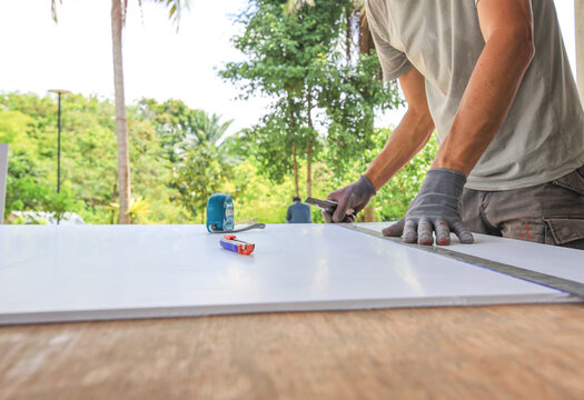 Man is working on a project, measuring and cutting a piece of wood