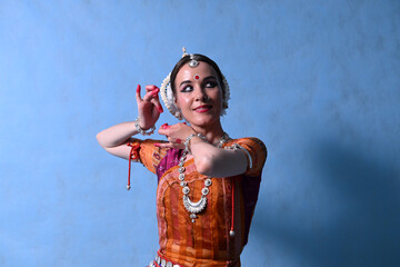Indian dancer in the studio on a blue background in a dance pose