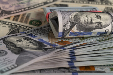 Close Up Stack of New One Hundred US Dollar Bills on Scattered Money Background