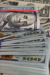 Close Up Stack of New One Hundred US Dollar Bills on Scattered Money Background