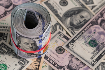 Close Up Roll of One Hundred US Dollar Bills Secured with Red Rubber Band