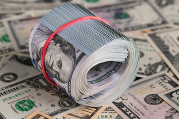 Close Up Roll of One Hundred US Dollar Bills Secured with Red Rubber Band