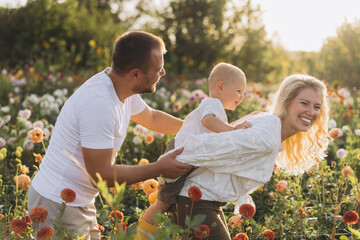 Family playing together in dahlia flower garden