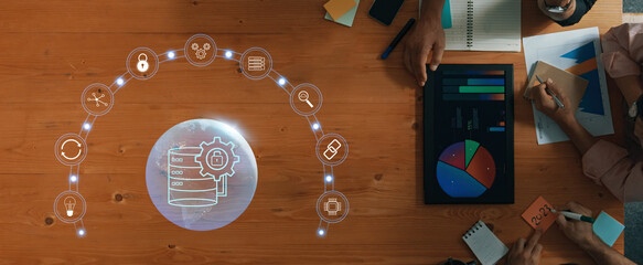 A top-down view of a workspace featuring data analysis elements, charts, and teamwork. The image illustrates the importance of insights and technology in decision-making. Trope