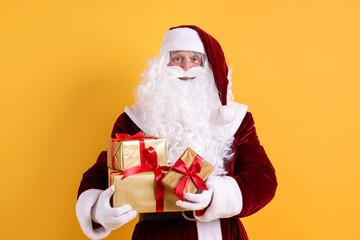Santa Claus with Christmas gifts on orange background