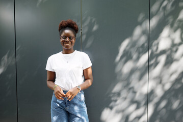 Smiling young woman outdoors against a clean background, showing confidence, positivity and authentic lifestyle for marketing and branding use.