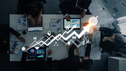 A team of professionals collaborates in a modern office environment, utilizing digital devices to analyze data and discuss strategies aimed at achieving business growth. Trope