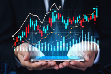 Dynamic image of hands holding a tablet displaying vibrant financial charts, illustrating stock market trends and data analysis in a modern business environment. Scalp