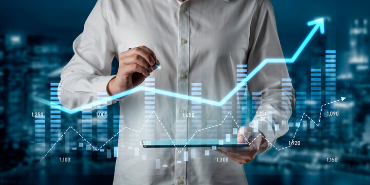 A business professional examines financial growth trends using a tablet. The digital graphs and urban background highlight data-driven decision making in the corporate world. Scalp - Powered by Adobe