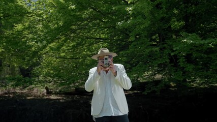 Man captures nature with analog camera in beautiful green park setting