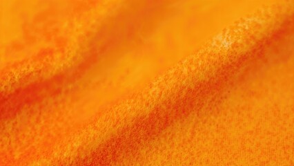 Close-up of textured orange fabric with soft folds and surface details.