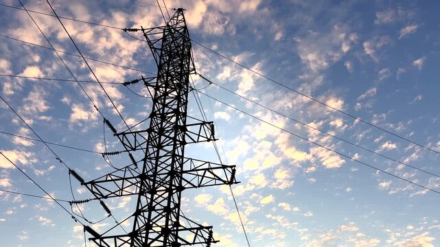 Transmission tower With ElectricWires on Colorful Sky in Farm Field. Power tower on sunset with clouds. Electrical Transmission Line Tower. High voltage electricity tower sky sunset landscape.