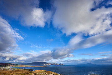 View over the ocean in cloudy blue sky weather with Achill island, Keel vilage and beach