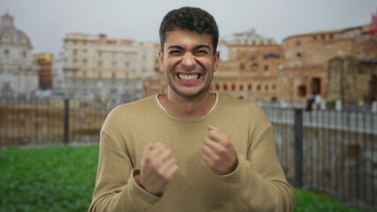 Man frames hands clasp rome backdrop while young hispanic tourist outdoor guy smile radiates...