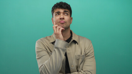 Man lifts hand slowly and pauses to think during a shoot against a background showcasing a young...