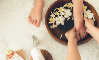 Woman indulges in blissful foot massage at luxurious spa salon while masseur give reflexology therapy in gentle day light ambiance resort or hotel foot spa. Quiescent