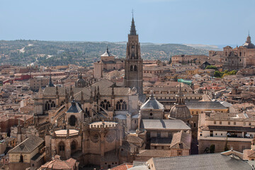 View of houses and rooftops with the tower and cathedral of Toledo, Spain.