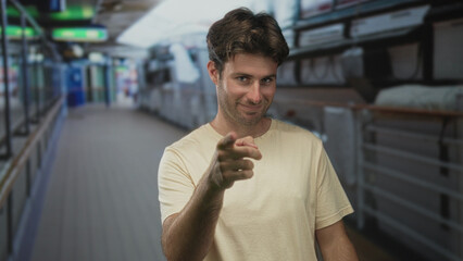 Man points finger at camera on cruise ship deck, bare hands forward, slight smile; playful...