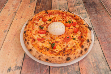 A burrata and pesto pizza features the creamy cheese in the center with a Genoa pesto base and roasted cherry tomatoes.