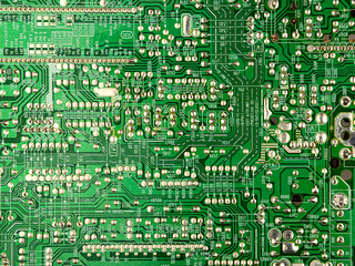 A close-up of a green printed circuit board from an electrical appliance or computer. Concept of...