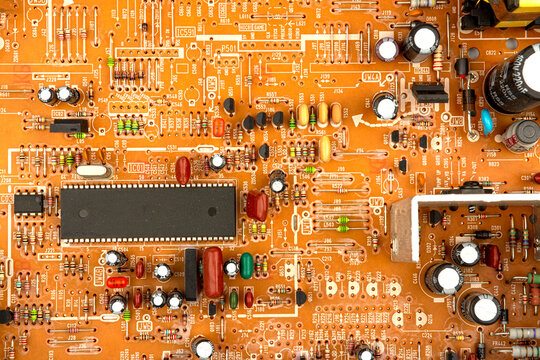 A close-up of a brown printed circuit board from a computer or electronic device. Concept of electronics and microprocessor technology
