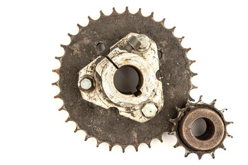 Old motorcycle sprockets, thickly coated with black oil and grease, on a white background. Perfect for motorcycle repair and maintenance topics.