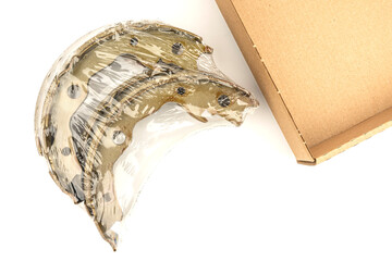 A close-up of new rear car brake pads with dark gray friction material and a metal backing. White background.