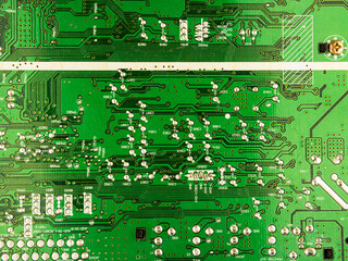 A close-up of a green printed circuit board from an electrical appliance or computer. Concept of electronics and microprocessor technology