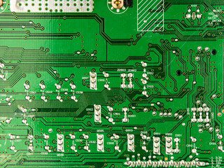 A close-up of a green printed circuit board from an electrical appliance or computer. Concept of electronics and microprocessor technology