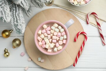 Tasty cocoa with marshmallows and Christmas decor on white wooden table, flat lay