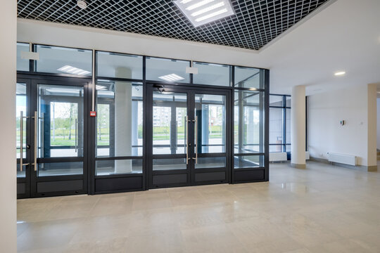 Glass entrance doors to a modern spacious office, view from inside the room