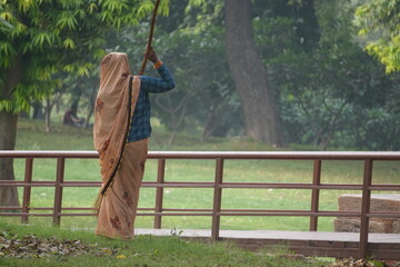 Traditional Indian Woman Sweeping in a Green Public Park