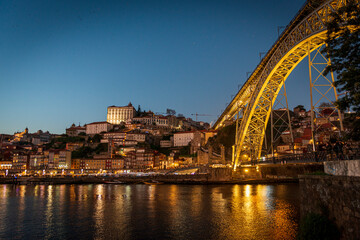 Oporto en hora azul junto al río con reflejos y puente, Porto blue hour by the river with...