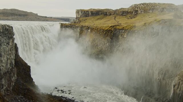An epic aerial view of Dettifoss, a powerful waterfall in Vatnaj&ouml;kull National Park, Iceland. The glacial river J&ouml;kuls&aacute; &aacute; Fj&ouml;llum cascades into a deep canyon, creating a majestic and misty scene in th