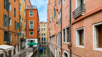 Fototapeta premium Narrow Venetian canal with stucco facades