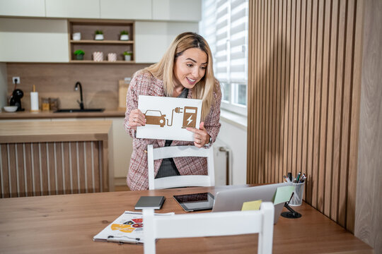 Woman presenting electric car charging concept during video call