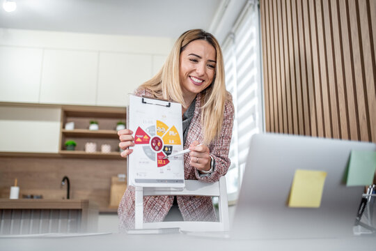 Businesswoman making video call presentation with chart from home