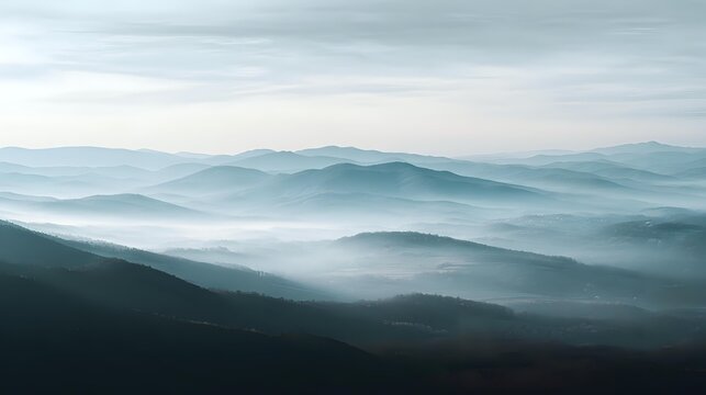 Misty mountain range landscape atmospheric blue tones creating a sense of depth and tranquility perfect for backgrounds and nature themes