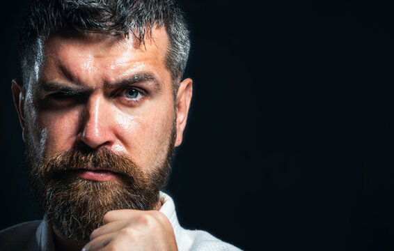 Karate man. Serious karate man in kimono in fighting stance, closeup portrait. Strong karate instructor with clenched fist. Karate fighter preparing for competition at gym. Copy space for advertising.