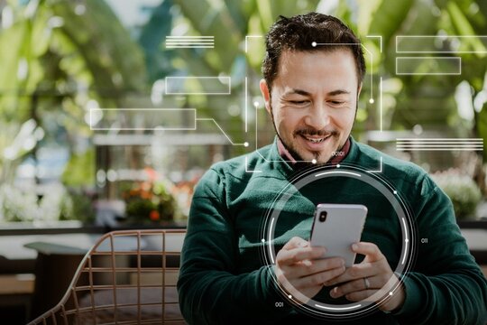 Happy man using a smartphone in a cafe