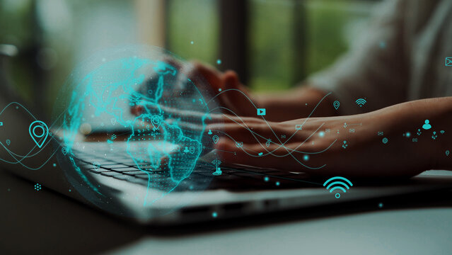 A close-up shot of hands typing on a laptop, enhanced by a digital overlay featuring a globe and connectivity icons, representing modern technology and communication. Xenic