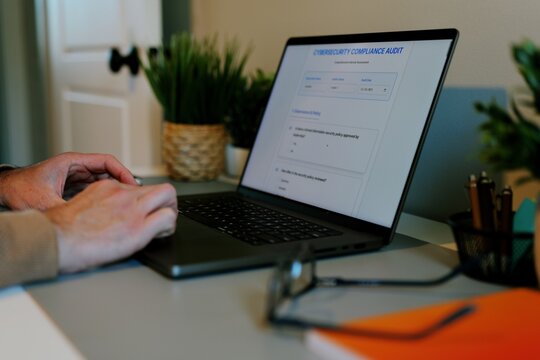 Middle Aged Man Working Remotely From Home Conducting Cybersecurity Audit for Consulting Firm - Information Security Concept