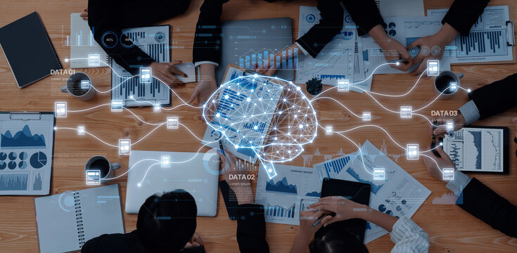 Group of professionals collaborating over data analysis with digital charts and a visualized brain concept on a wooden table, embodying innovation and teamwork. Trope