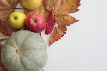Pumpkin and apples laying  on white table