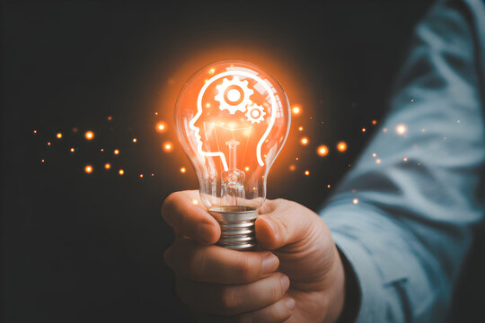 Hand holding a glowing lightbulb with a head and gears inside symbolizing innovation creativity and problemsolving perfect for business technology and educational concepts and ideas
